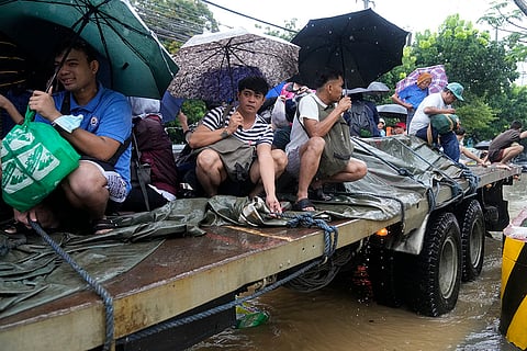 Philippines Tropical Storm Yagi: Residents ride a truck as they negotiate a flooded street in Cainta